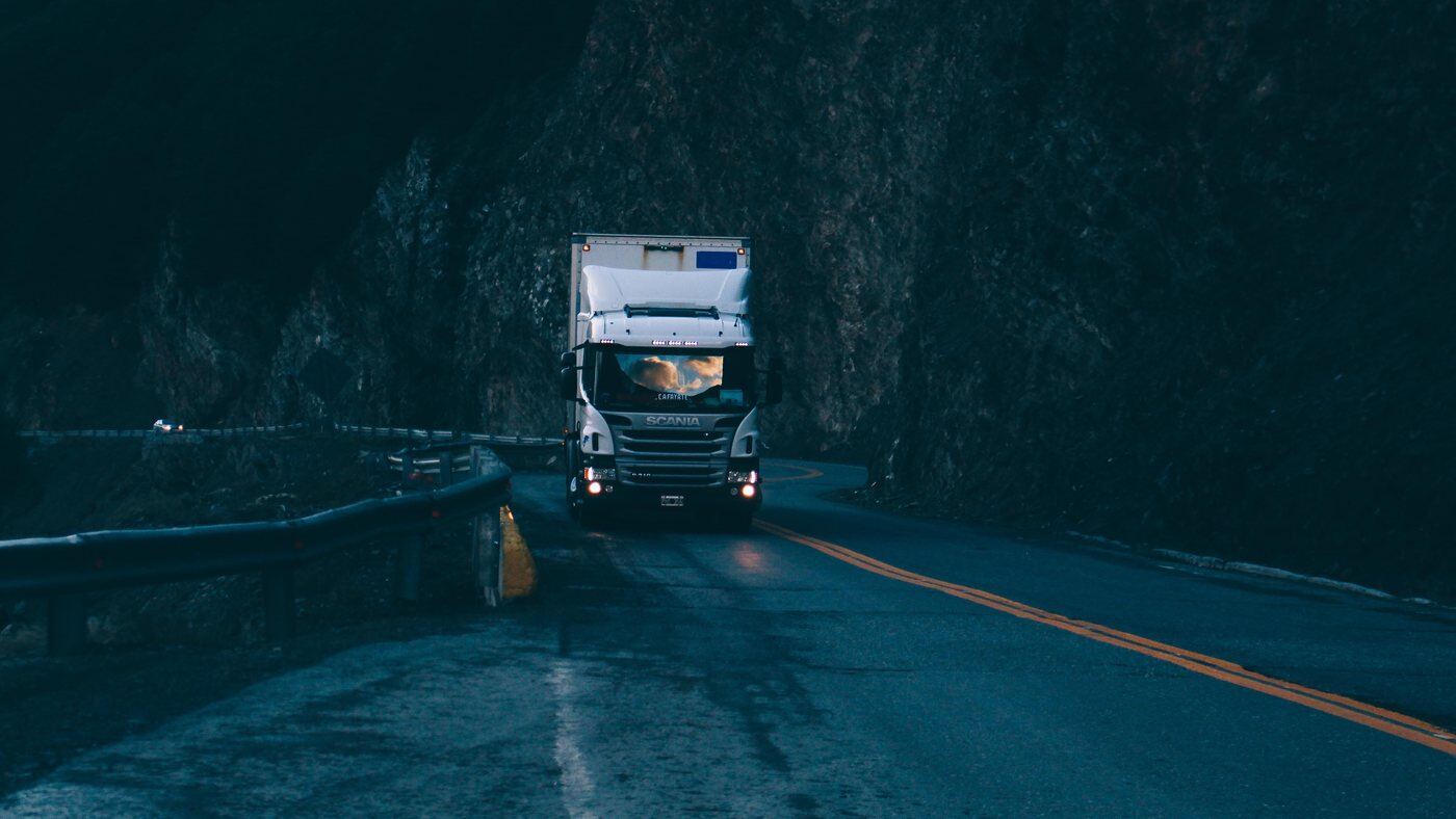 Temperature-controlled lorry on a mountain road at dusk